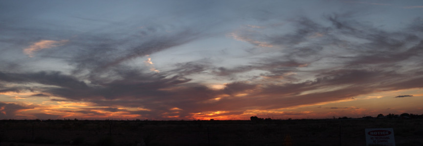 [Several images joined to show a large expanse of sky, both horizontally and vertically. The sun has already set, but there is still a patch of red-orange color at the horizon. Above it are 